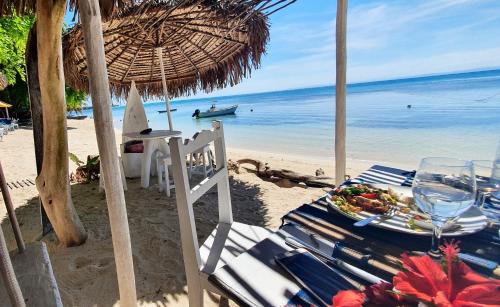 a table with a plate of food on the beach at Hotel ECOLODGE LE RAVORAHA in Sainte Marie
