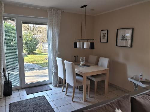 ein Esszimmer mit einem Tisch, Stühlen und einem Fenster in der Unterkunft Ferienwohnung Jürgens in Rheinbreitbach