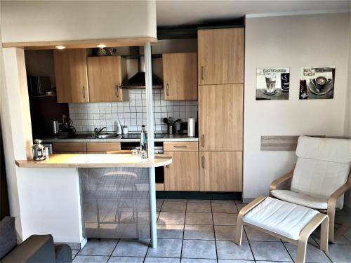 a kitchen with wooden cabinets and a table and a chair at Ferienwohnung Jürgens in Rheinbreitbach