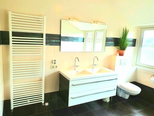 a bathroom with a sink and a toilet at Appartement Schoorl in Schoorl