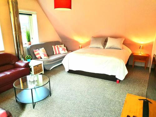 salon z łóżkiem i kanapą w obiekcie Appartement Schoorl w mieście Schoorl