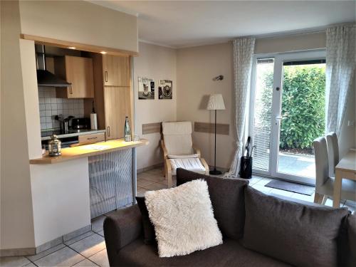 a kitchen and a living room with a couch and chairs at Ferienwohnung Jürgens in Rheinbreitbach