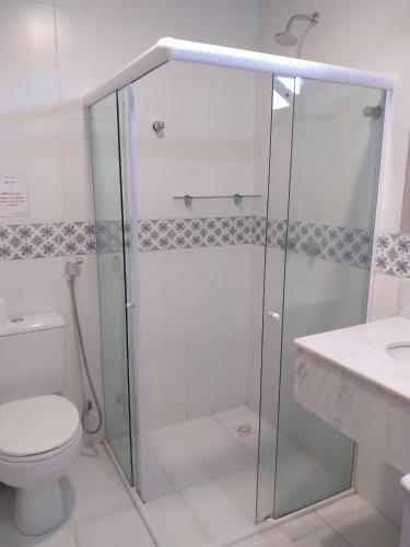 a bathroom with a shower and a toilet and a sink at Pousada Zazen in Vale do Capao