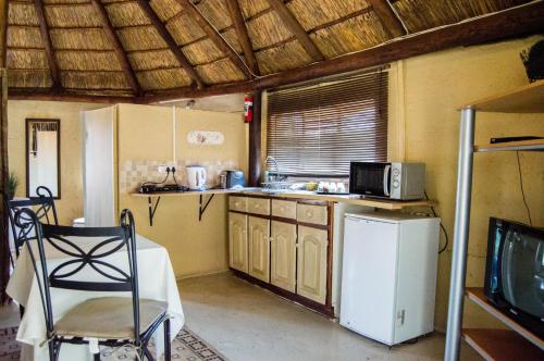 a kitchen with a white refrigerator and a microwave at Shangrila-innibos Country Lodge in Hartbeespoort