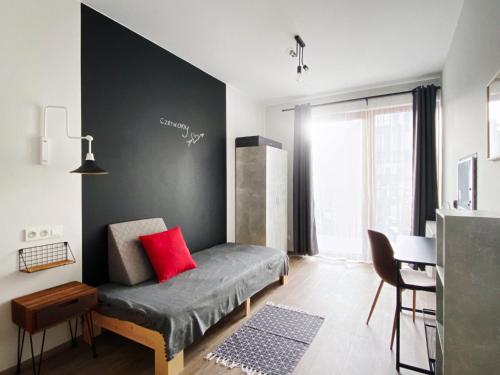 Un dormitorio con una cama con una almohada roja. en 3 Kolory - pokoje w mieszkaniu współdzielonym, en Varsovia