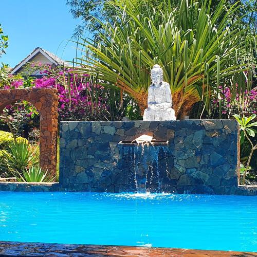 a fountain in the middle of a swimming pool at Hotel ECOLODGE LE RAVORAHA in Sainte Marie