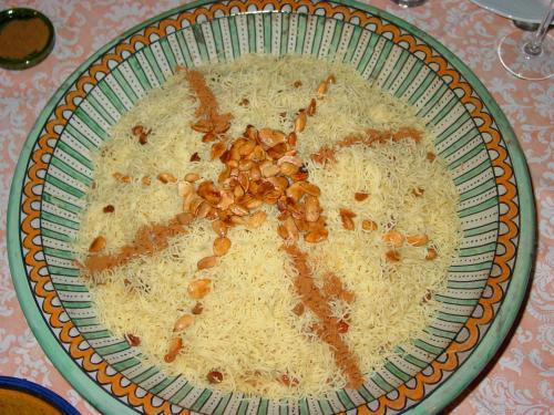 a bowl of rice with nuts on top of it at Dar Paru in Mhamid