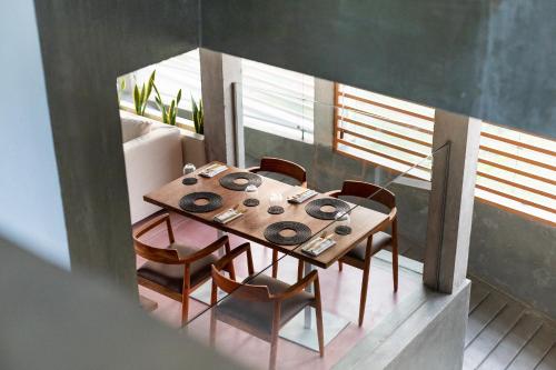 a dining room with a wooden table and chairs at Harding Boutique Hotel in Ahangama