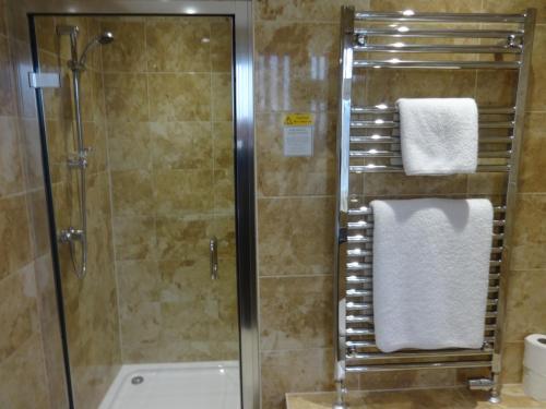 a bathroom with a shower with a glass shower stall at Autumn House in Cambridge