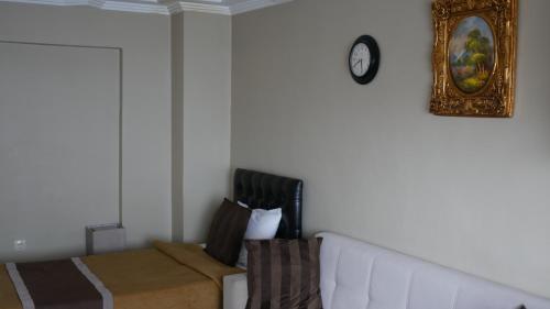a bedroom with a couch and a clock on the wall at Lena Central Flats in Bursa