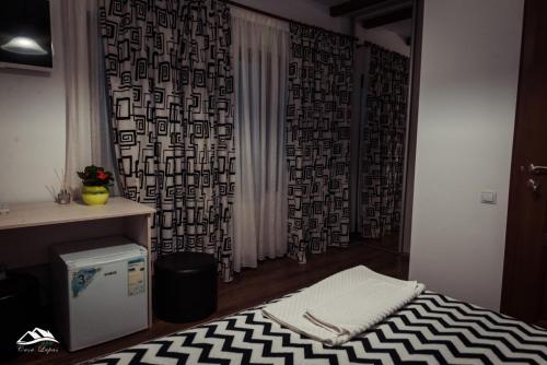 a bedroom with a bed with a black and white rug at Pensiunea Casa Lupas in Gilău
