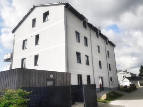 a white building with a fence in front of it at Ferienwohnung Wellenreiter in Sassnitz