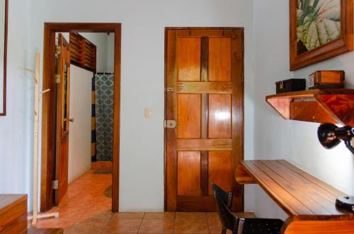 a dining room with a table and a wooden door at Tico Adventure Lodge in Sámara