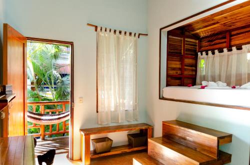 a room with a bed and a window and a table at Tico Adventure Lodge in Sámara
