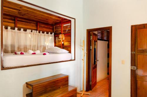a bedroom with a bed with a mirror on the wall at Tico Adventure Lodge in Sámara