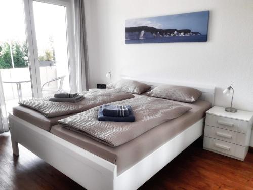 a bed in a white room with a large window at Ferienwohnung Wellenreiter in Sassnitz