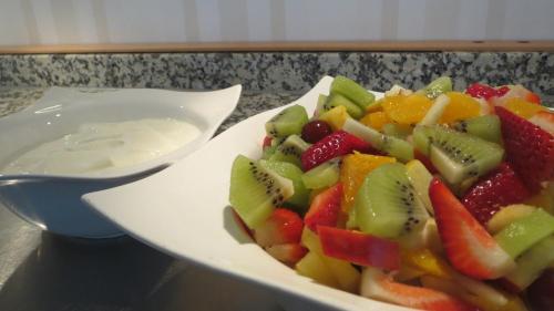a plate of fruit on a table with a spoon at Lindner's Hotel in Bellheim