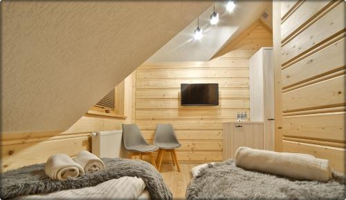 a bedroom with a bed and a tv in a room at Zdrojowy Gościniec - domki Rabka-Zdrój in Rabka