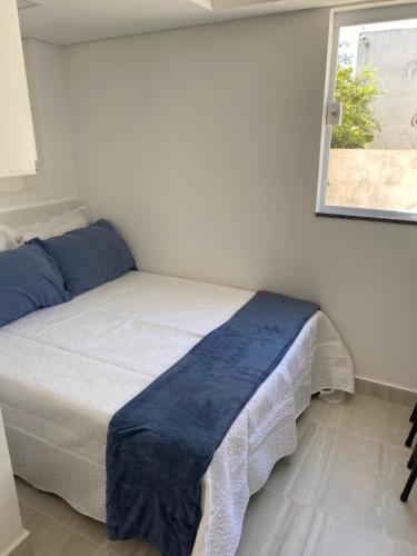 a bedroom with a bed with a blue blanket on it at Pedra Branca in Campinas