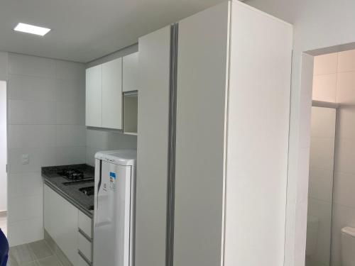 a kitchen with white cabinets and a refrigerator at Pedra Branca in Campinas