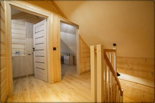 a hallway with a door and a staircase in a house at Zdrojowy Gościniec - domki Rabka-Zdrój in Rabka
