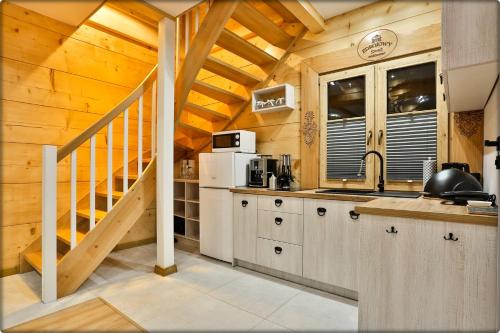 a kitchen with a staircase in a wooden house at Zdrojowy Gościniec - domki Rabka-Zdrój in Rabka