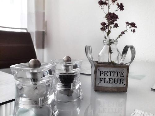 a table with two glass jars and a vase with a picture of flowers at Ferienwohnung Wellenreiter in Sassnitz