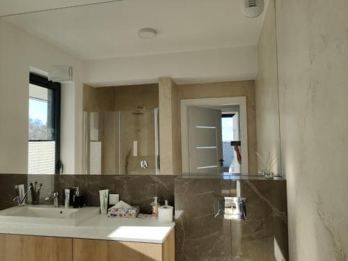 a bathroom with a sink and a large mirror at Apartament Kapitana Sea Wave in Darłówko