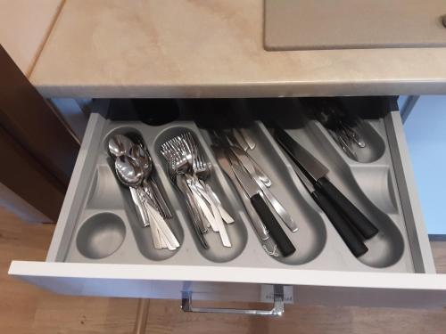 a drawer with silver utensils in a cabinet at Academy Apartment Cieszyn in Cieszyn