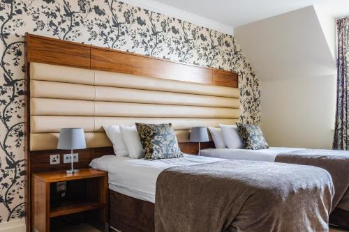 two beds in a hotel room with a headboard at Westport Country Lodge Hotel in Westport