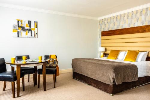 a bedroom with a bed and a table and chairs at Westport Country Lodge Hotel in Westport