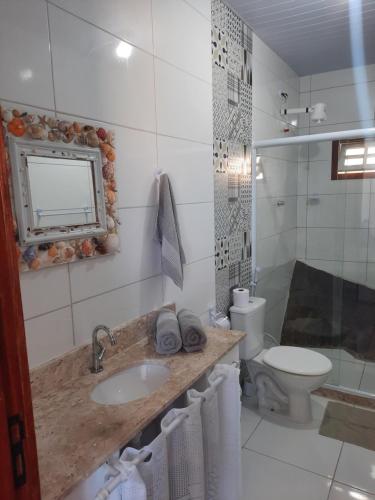 a bathroom with a sink and a toilet at Bela Vista Flats in Arraial do Cabo