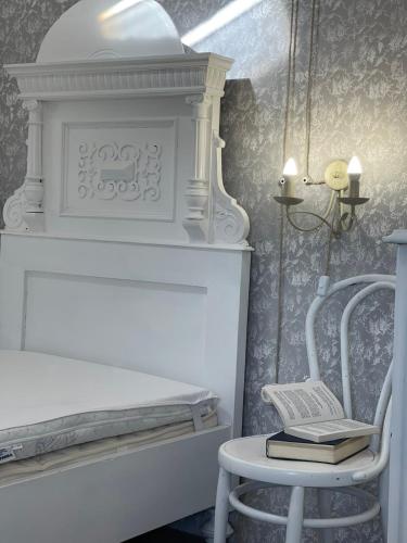 a bedroom with a bed and a chair with books at Lubenice-Rodinis Room and Apartment in Lubenice