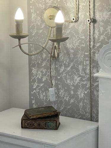 a lamp with two candles on top of a table at Lubenice-Rodinis Room and Apartment in Lubenice