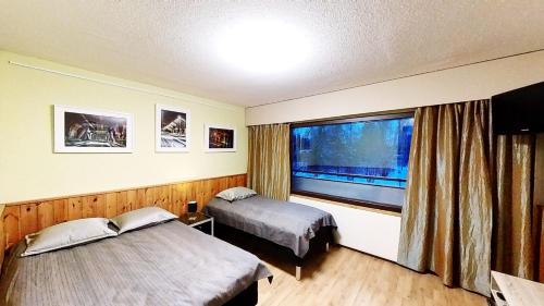 Habitación de hotel con 2 camas y ventana en ART Hotel JUNA, en Imatra