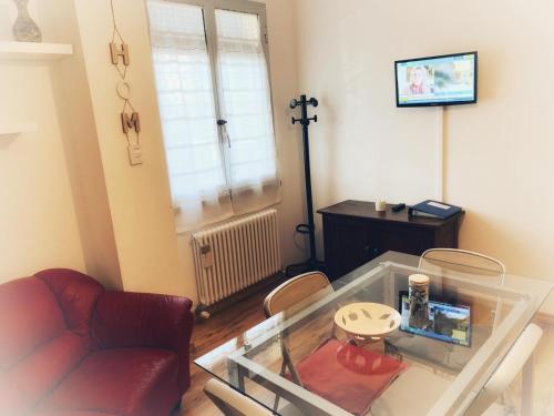 een woonkamer met een rode bank en een glazen tafel bij Quaranta Short Stays in Reggio Emilia
