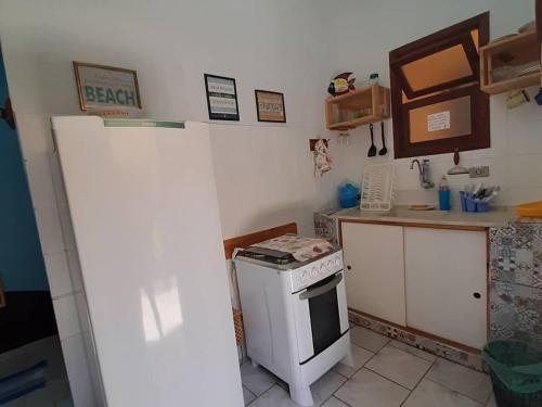 a small kitchen with a stove and a counter at Residencial Maresias Suites e Chalés in Maresias