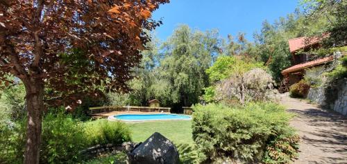 a garden with a swimming pool in a yard at Casa de Montaña inmersa en Bosque Nativo in San José de Maipo