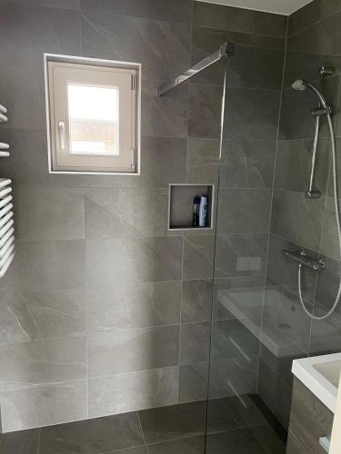 a bathroom with a shower with a glass door at Vakantie huis aan het water in Rijpwetering