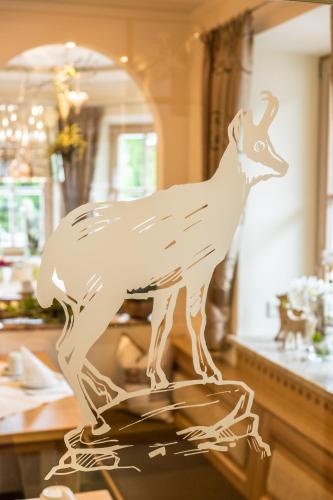 a wooden statue of a deer on a table at Hotel Alpspitz B&B in Grainau