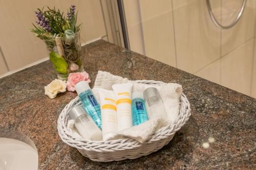 a basket of toothbrushes on a counter in a bathroom at Hotel Alpspitz B&B in Grainau