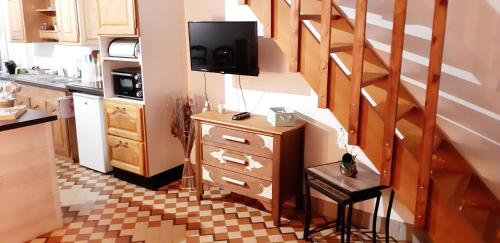 Il comprend une cuisine avec un escalier et une télévision murale. dans l'établissement maison berck proche de la plage, à Berck-sur-Mer