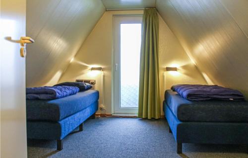 Cette chambre mansardée comprend 2 lits et une fenêtre. dans l'établissement Nice Home In Gramsbergen With Indoor Swimming Pool, à Gramsbergen