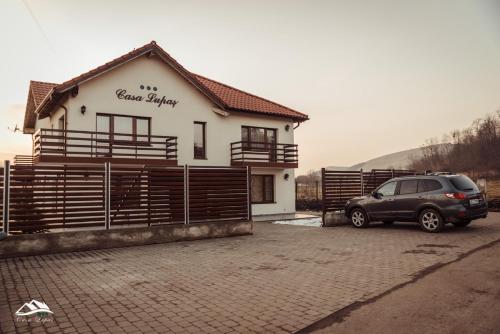 a car parked in front of a house at Pensiunea Casa Lupas in Gilău