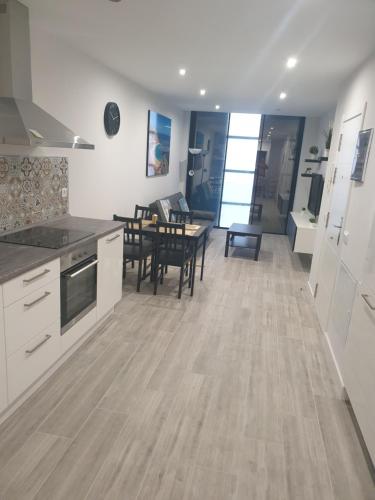 a kitchen and living room with a table and chairs at Guanarteme Vista Surf in Las Palmas de Gran Canaria