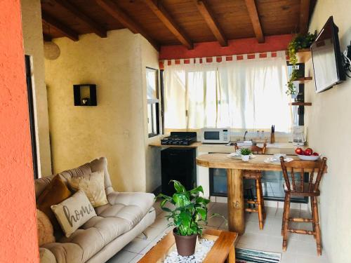 a living room with a couch and a table at Departamento Rinconcito olivo, 5min centro, home office in Valle de Bravo