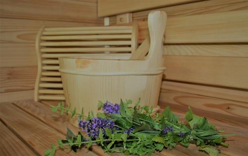 a tub with a bucket and a bunch of flowers at HERBALIJA Apartment Herbalija - sorrounded by Nature in Podčetrtek