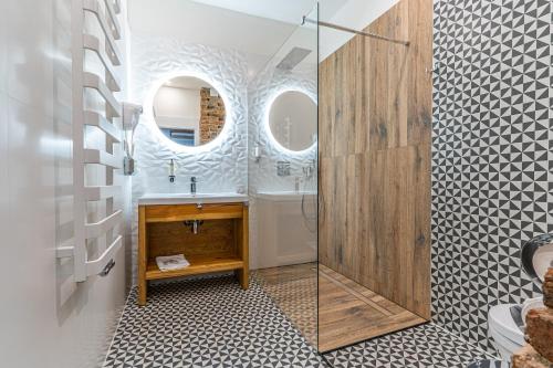 y baño con lavabo y ducha acristalada. en Boutique Penzion Slovakia & Slovakia Residence en Košice