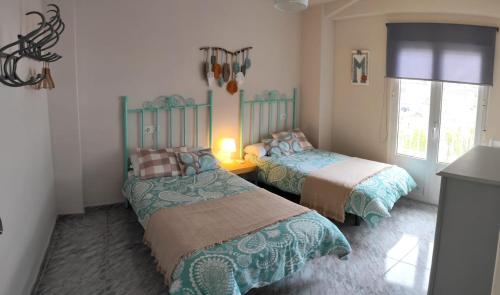 a bedroom with two beds and a window at La Casa De Mariana in Cazorla