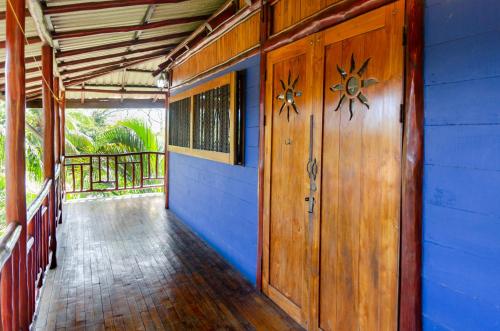 a house with a wooden door and a porch at Tico Adventure Lodge in Sámara